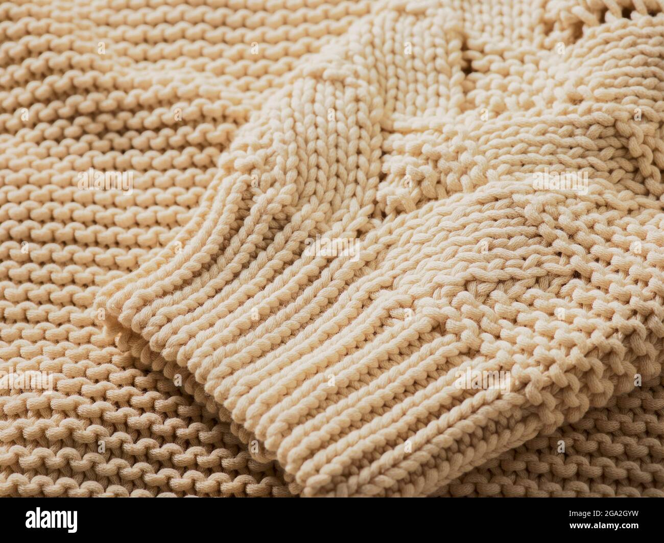 Extreme close-up of the cuff of a cream-coloured knit sweater; Studio Stock Photo