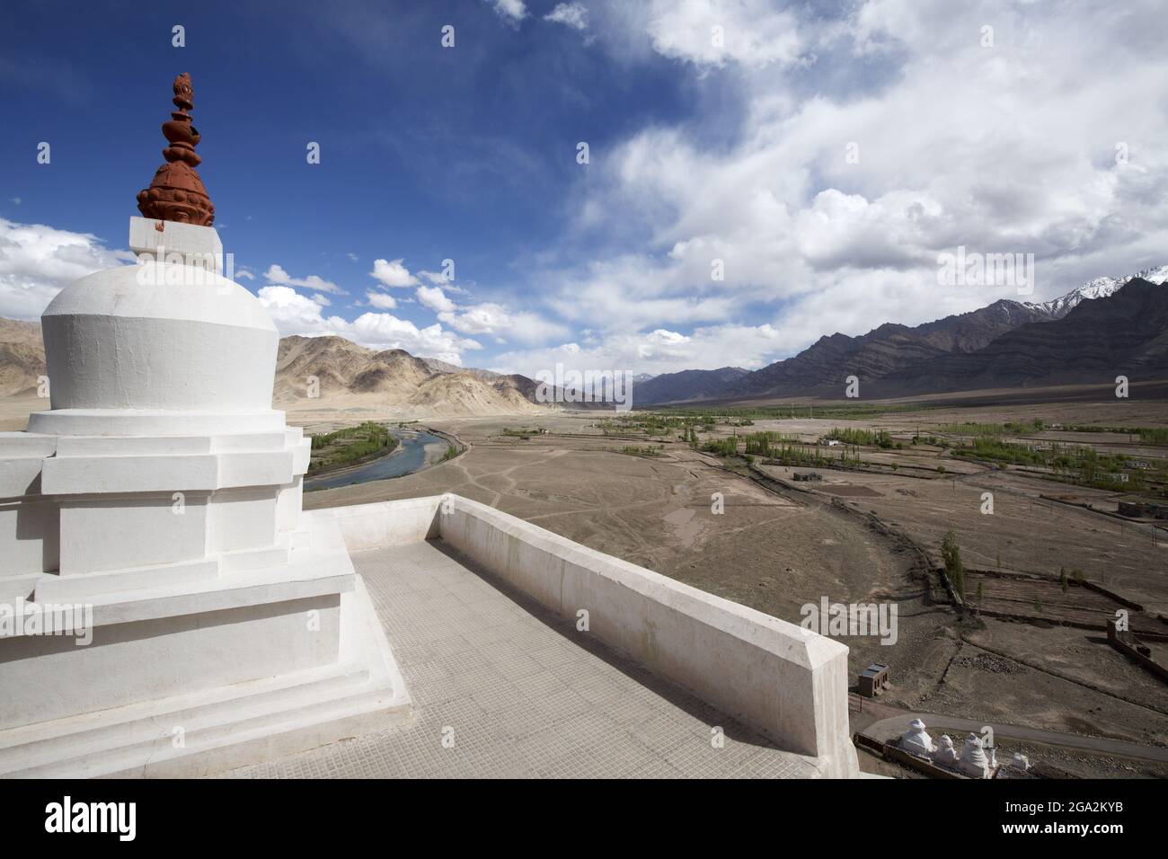 Close-up of the concrete, rooftop walkway at the Stakna Monastery with its whitewashed Buddhist stupa (known as chortens in Tibetan Culture) and th... Stock Photo