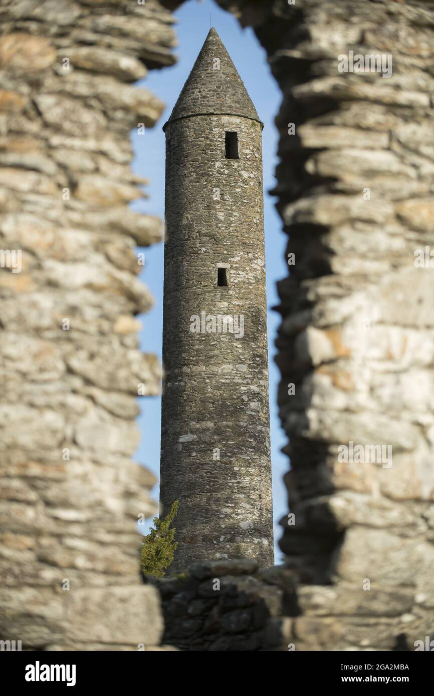 Close-up of the Round Tower through a lancet window opening at Glendalough (or The valley of the Two Lakes) the site of an early Christian monastic... Stock Photo