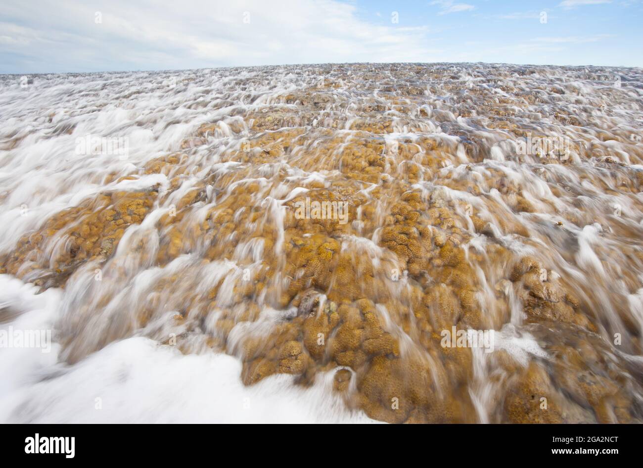 Close-up of water cascading off of Montgomery Reef with its frothy sea surf as it emerges out of the ocean while the tide goes out in Camden Sound Stock Photo