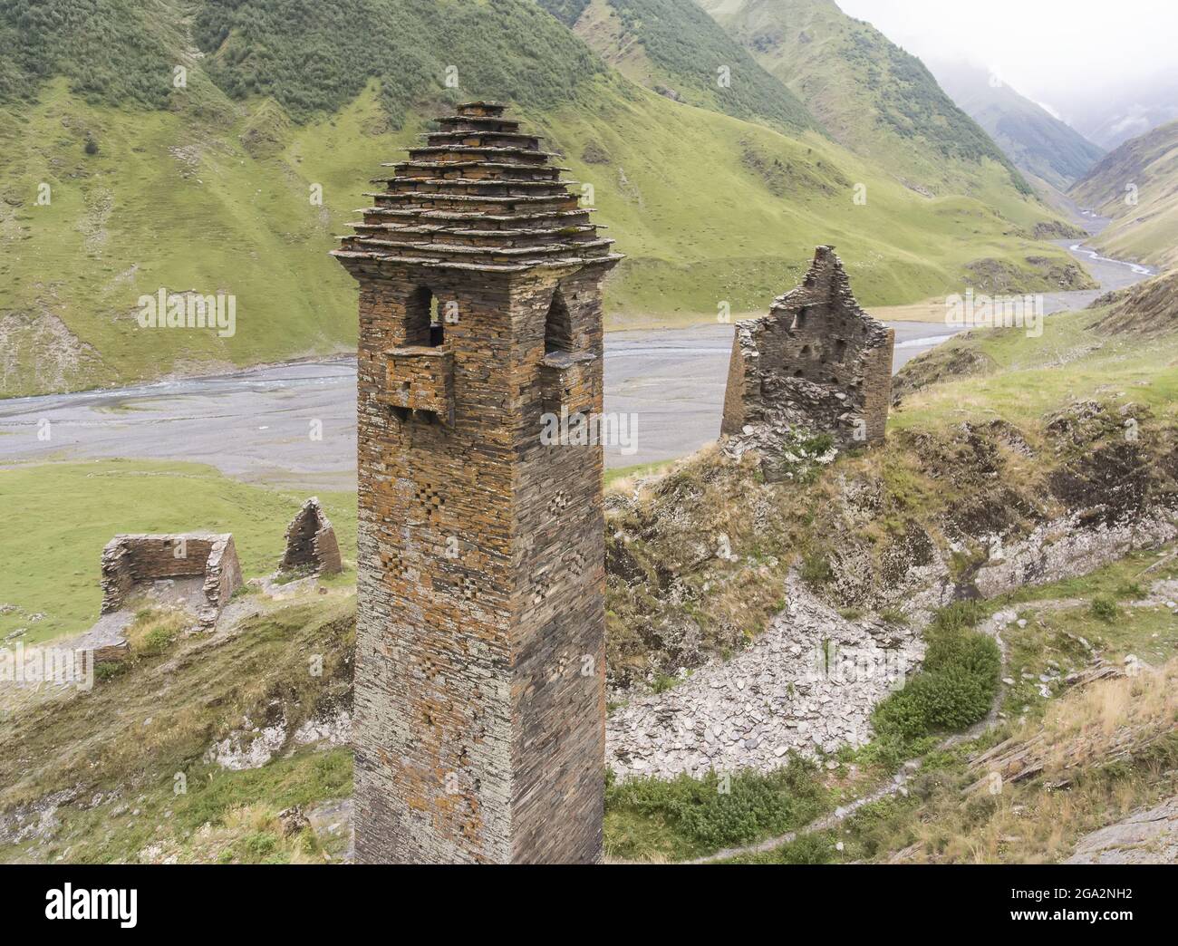 The ruins of abandoned stone watch towers, one with the traditional step pyramidal roof, at the mountainside village of Girevi in the Tusheti Natio... Stock Photo