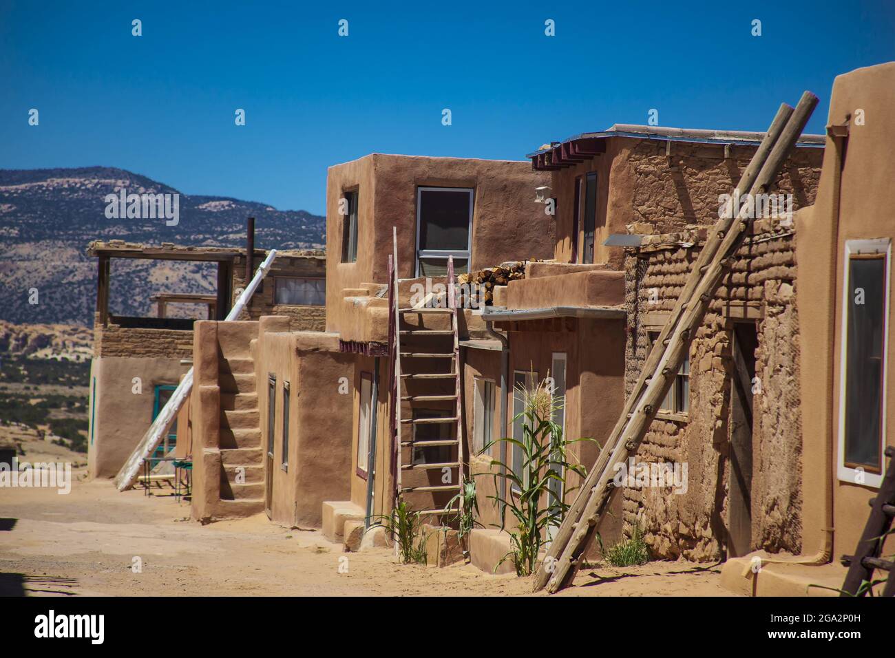 Adobe apartment dwellings in the ancient indigenous community of Acoma Pueblo with doors and windows installed over the years. The Acoma people sti... Stock Photo