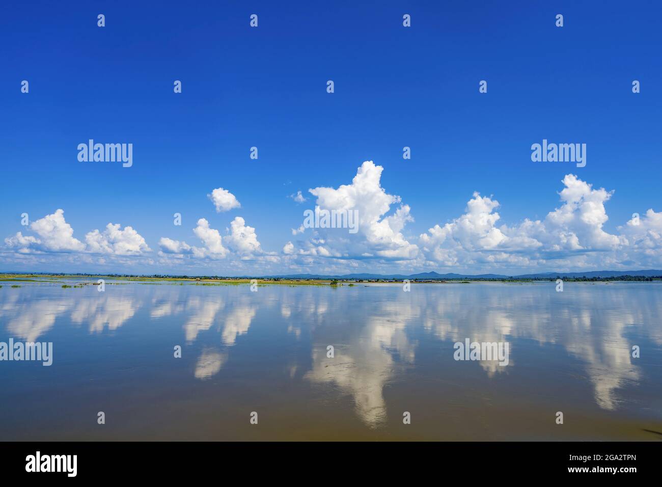 Clouds over the banks of the Ayeyarwady (Irrawaddy) river with the mirror image of clouds in the water in Kachin State, Myanmar/Burma; Kachin, Myanmar Stock Photo