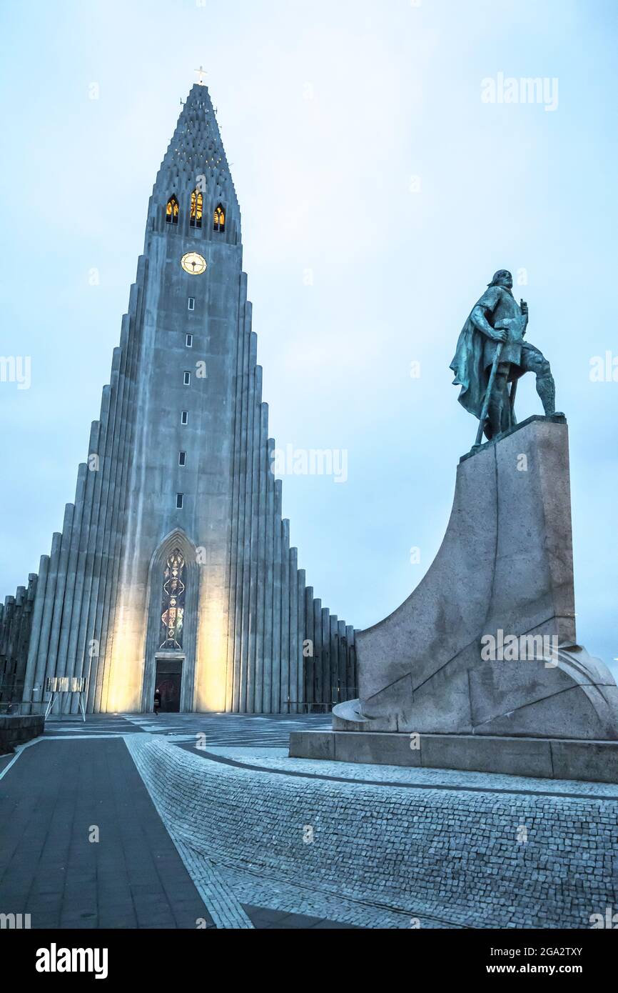 The Hallgrimskirkja illuminated, Lutheran cathedral with a statue of the famous explorer Leif Erikson in front that predates the church, the first ... Stock Photo