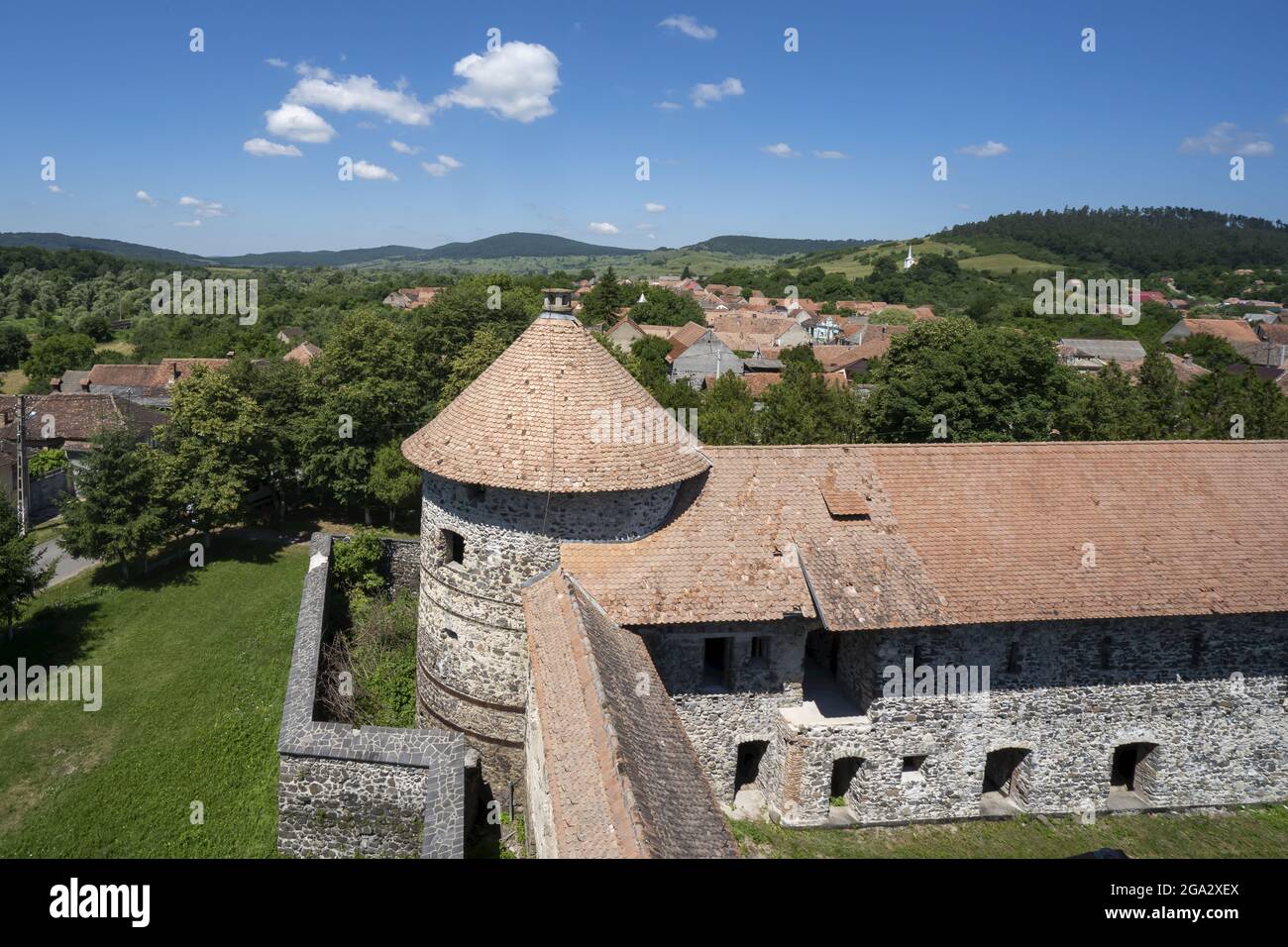 Overlooking the town and the round tower of the Cetatea Bethlen Medieval Castle in Racos; Racos, Transylvania, Romania Stock Photo