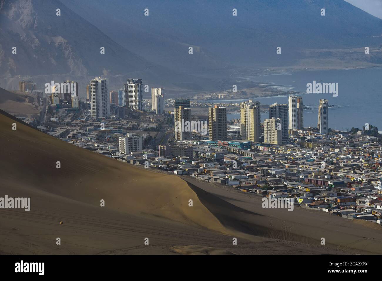 South part of the port city of Iquique with skyline and Cerro Dragon (Dragon Hill) the large, urban sand dune that overlooks the city Stock Photo