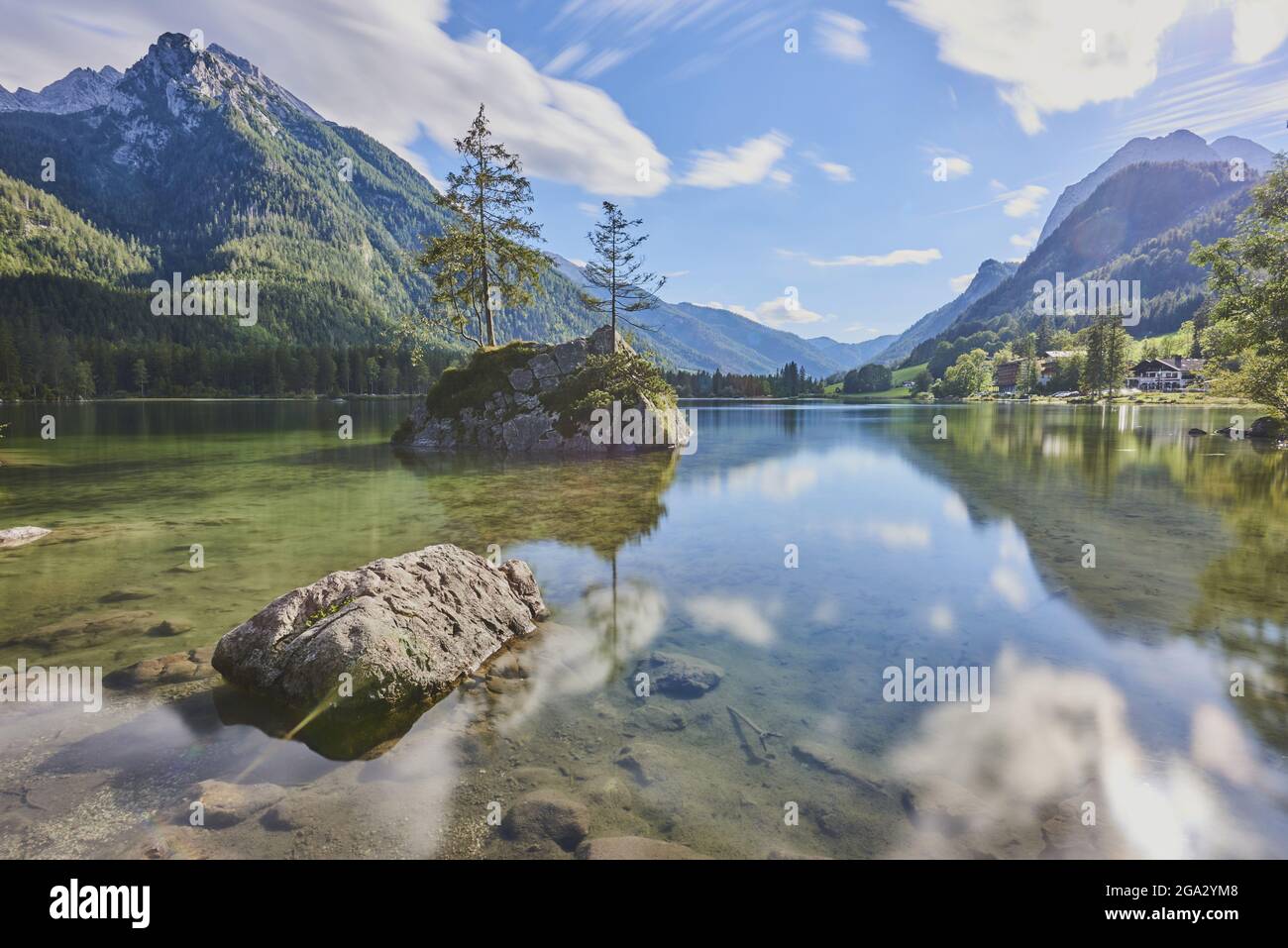 Norway spruce (Picea abies) tree on a small, rock island in the clear waters of Lake Hintersee, Bavarian Alps Stock Photo