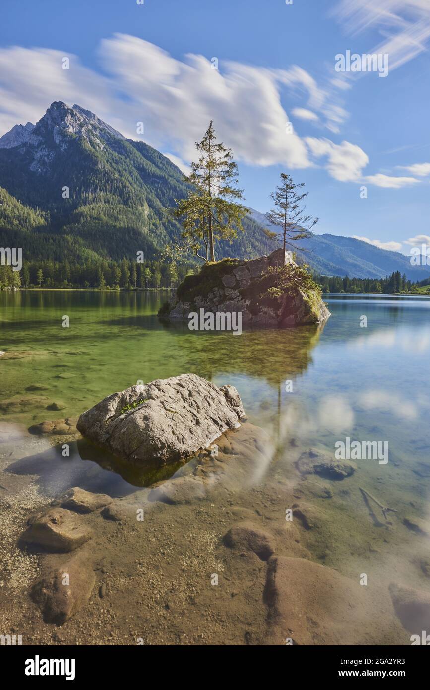 Norway spruce (Picea abies) tree on small, rock island in the clear waters of Lake Hintersee, Bavarian Alps Stock Photo