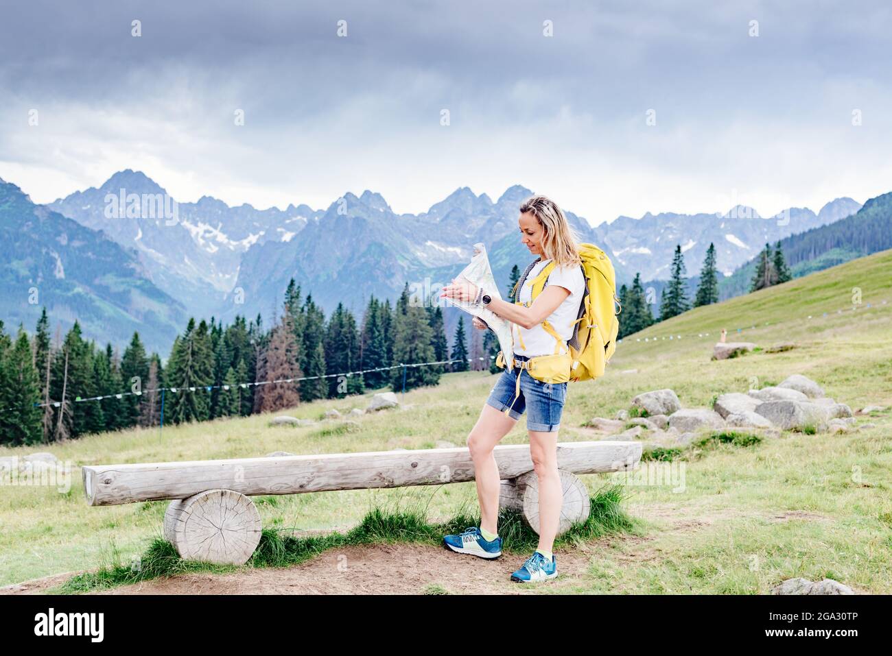 Happy female hiker with paper map in the mountains Stock Photo - Alamy