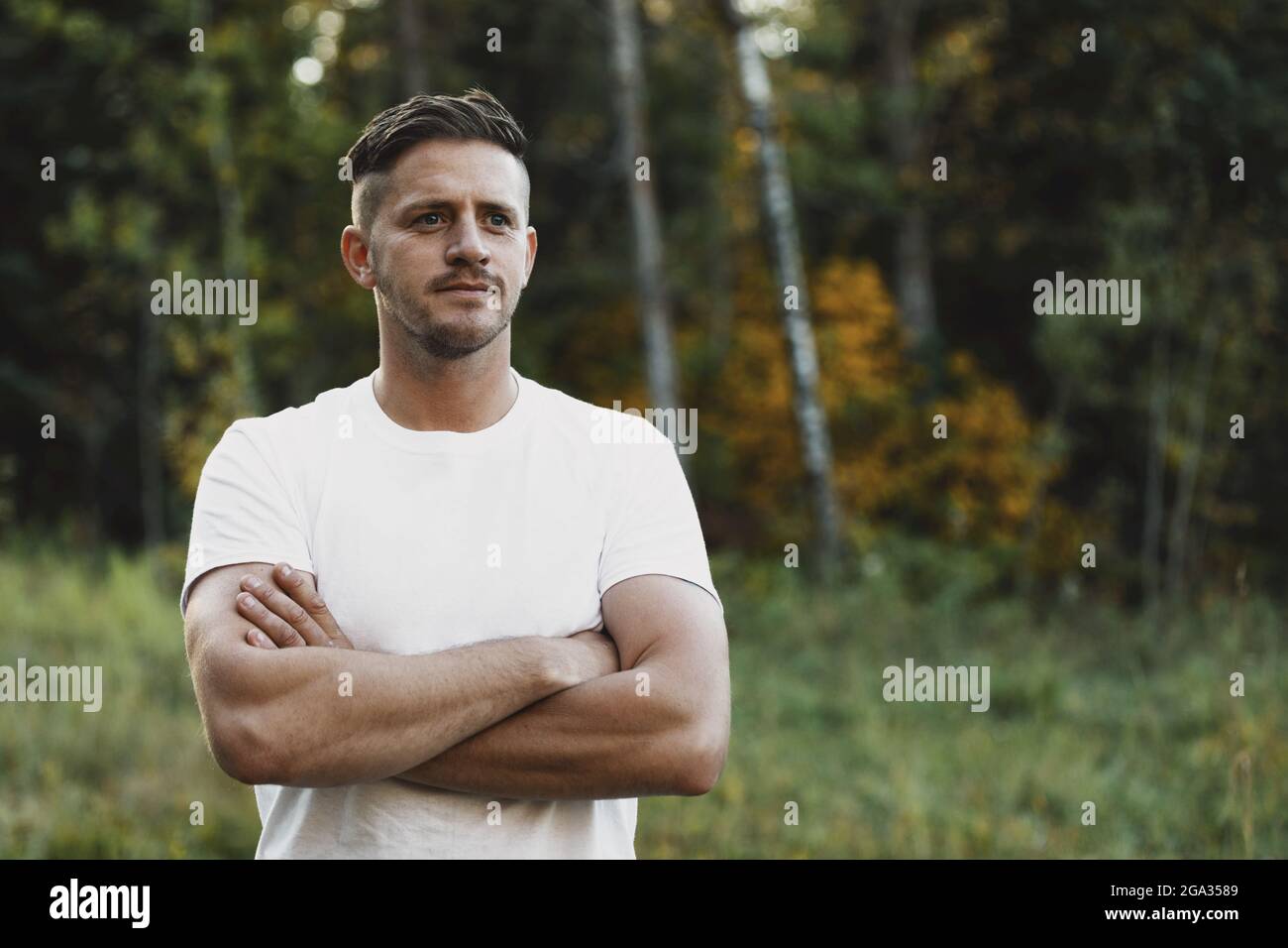 Portrait of a man with folded arms outdoors in a city park during the fall season; Edmonton, Alberta, Canada Stock Photo