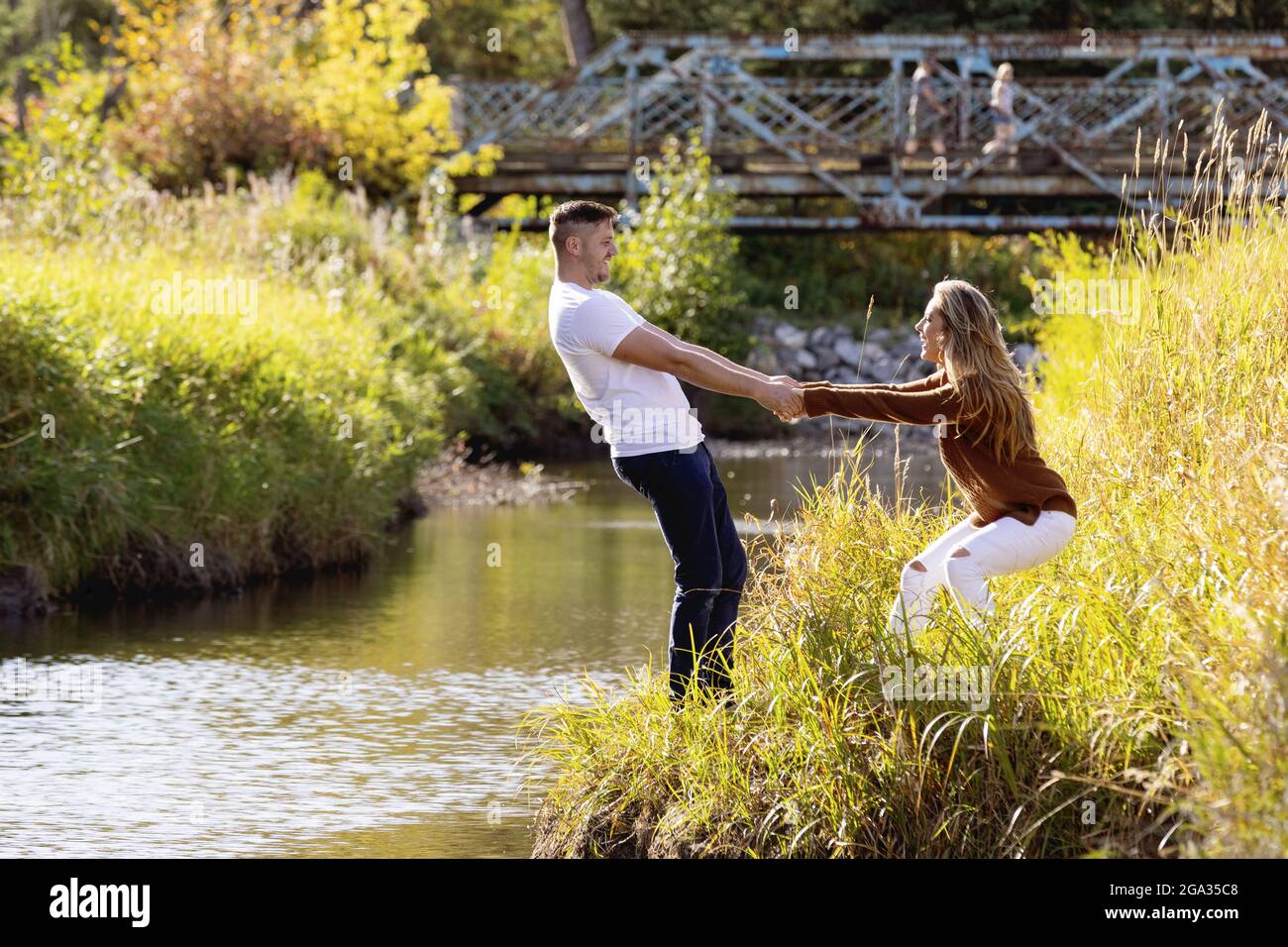 Husband and wife spending quality time together outdoors near a stream in a city park; Edmonton, Alberta, Canada Stock Photo