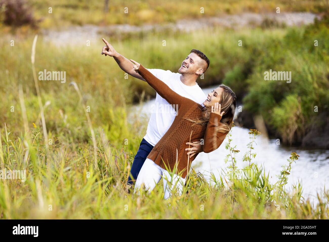 Husband and wife spending quality time together outdoors near a stream in a city park; Edmonton, Alberta, Canada Stock Photo