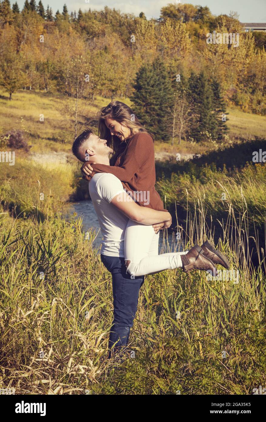 Husband and wife spending quality time together outdoors near a stream in a city park; Edmonton, Alberta, Canada Stock Photo