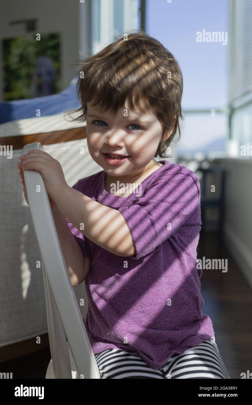Girl sitting on chair smiling hi-res stock photography and images - Alamy