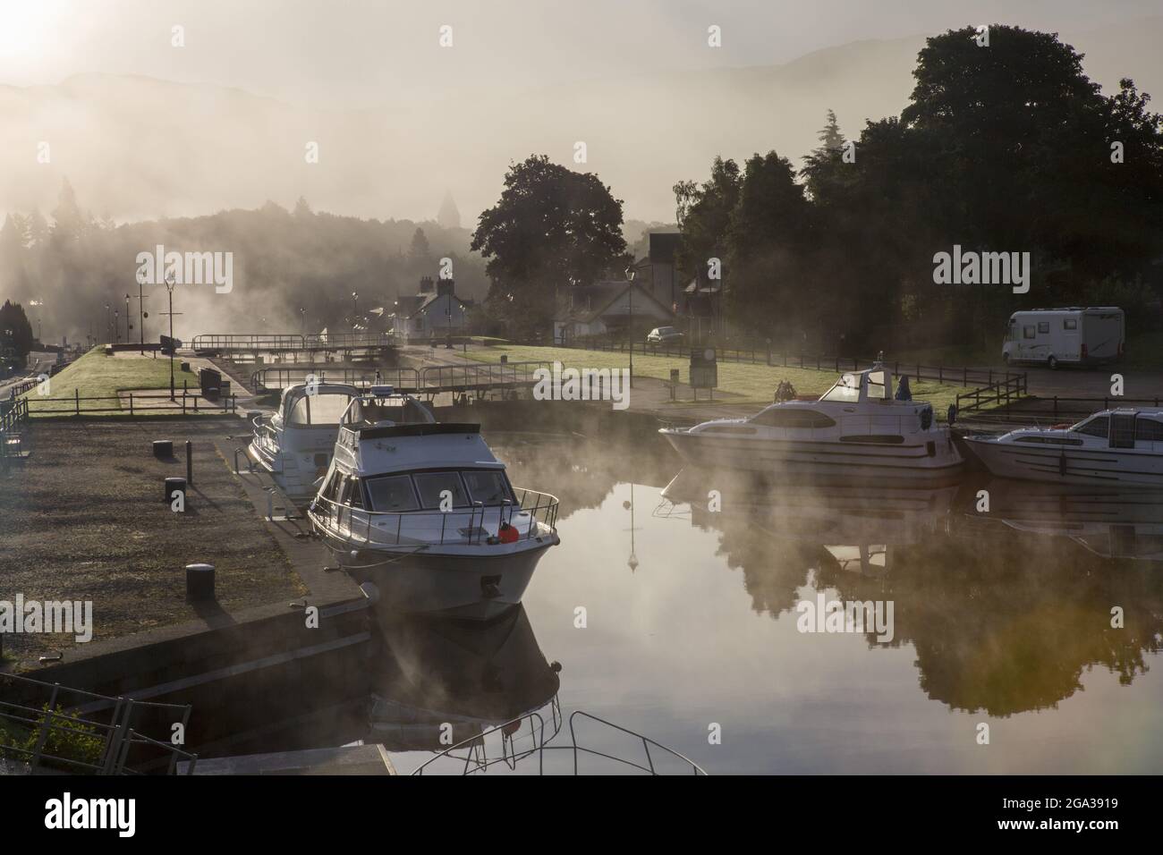 As the sun rises, fog lifts along the Caledonian Canal at Fort Augustus, Scotland; Fort Augustus, Scotland Stock Photo