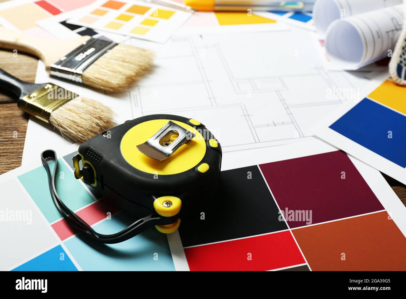 Construction instruments, plan and brushes on wooden table background ...