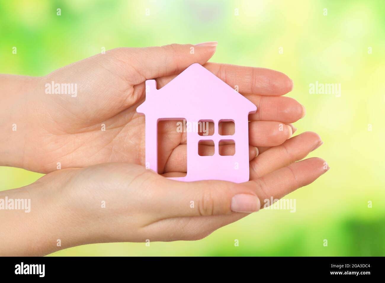 Female hands holding model of house on bright background Stock Photo ...