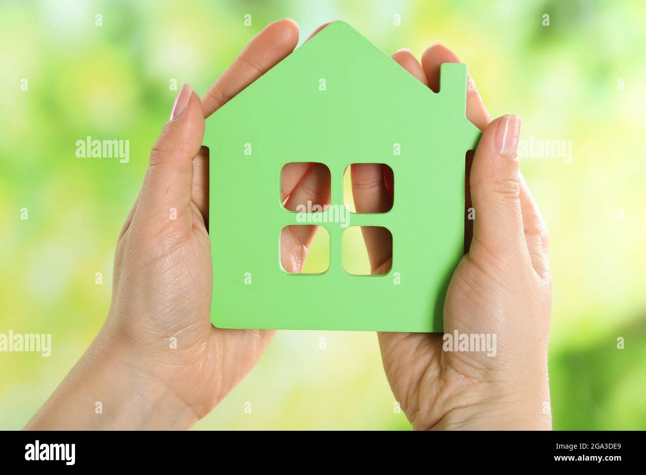 Female hands holding model of house on bright background Stock Photo ...