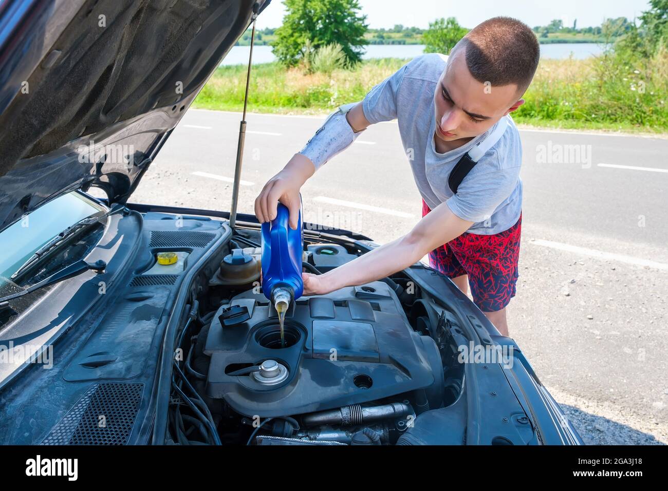 Man with an amputated arm pouring oil, adding engine oil in engine
