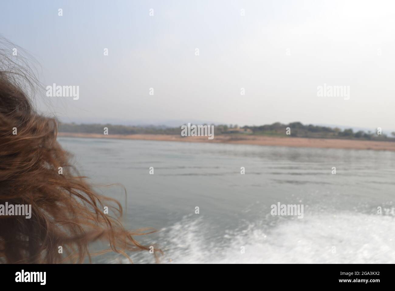 Soft hair moving with the wind during boat ride which gives a calm sensation when the eyes finally focus the hair. Stock Photo