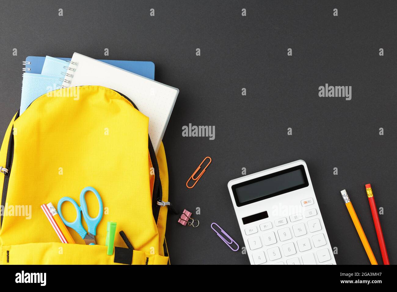 School supplies in a yellow backpack. Stock Photo