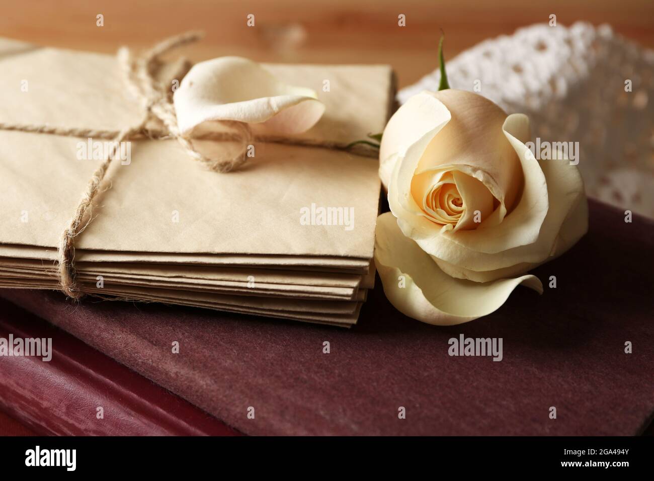 Thiết kế trang trí tiệc cưới với hoa hồng tươi, sách cũ và chữ cái trên bàn gỗ màu nâu cổ điển sẽ làm tăng thêm sự đặc biệt, đầy sáng tạo và nổi bật. Bức ảnh này sẽ mang lại cho người xem cảm giác thoải mái và tâm trạng vui tươi.