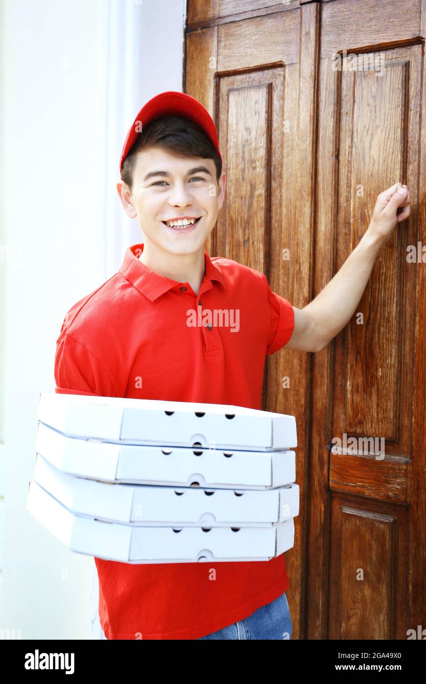 Young man delivering pizza box near house Stock Photo Alamy