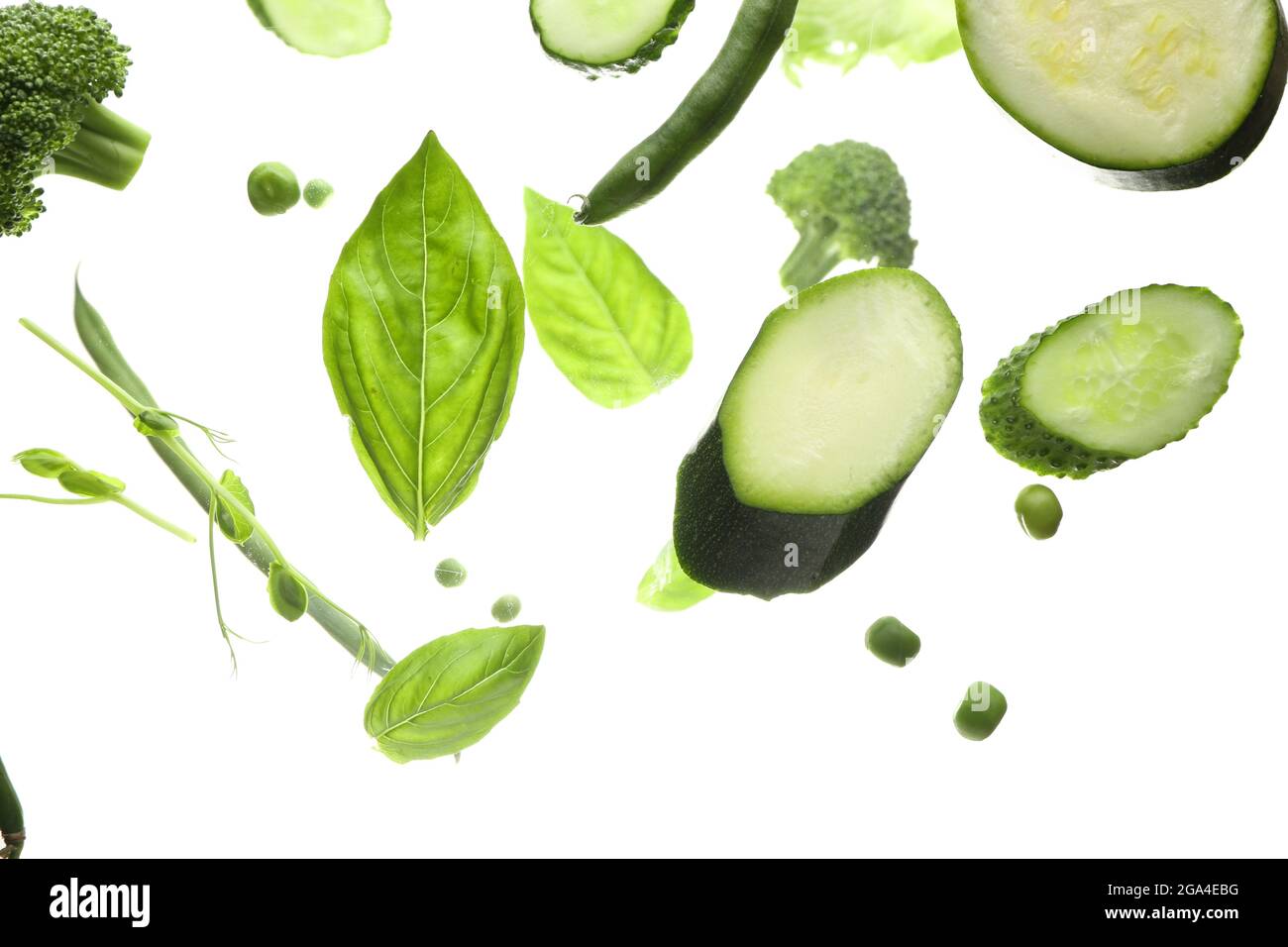 Flying green vegetables on white background Stock Photo