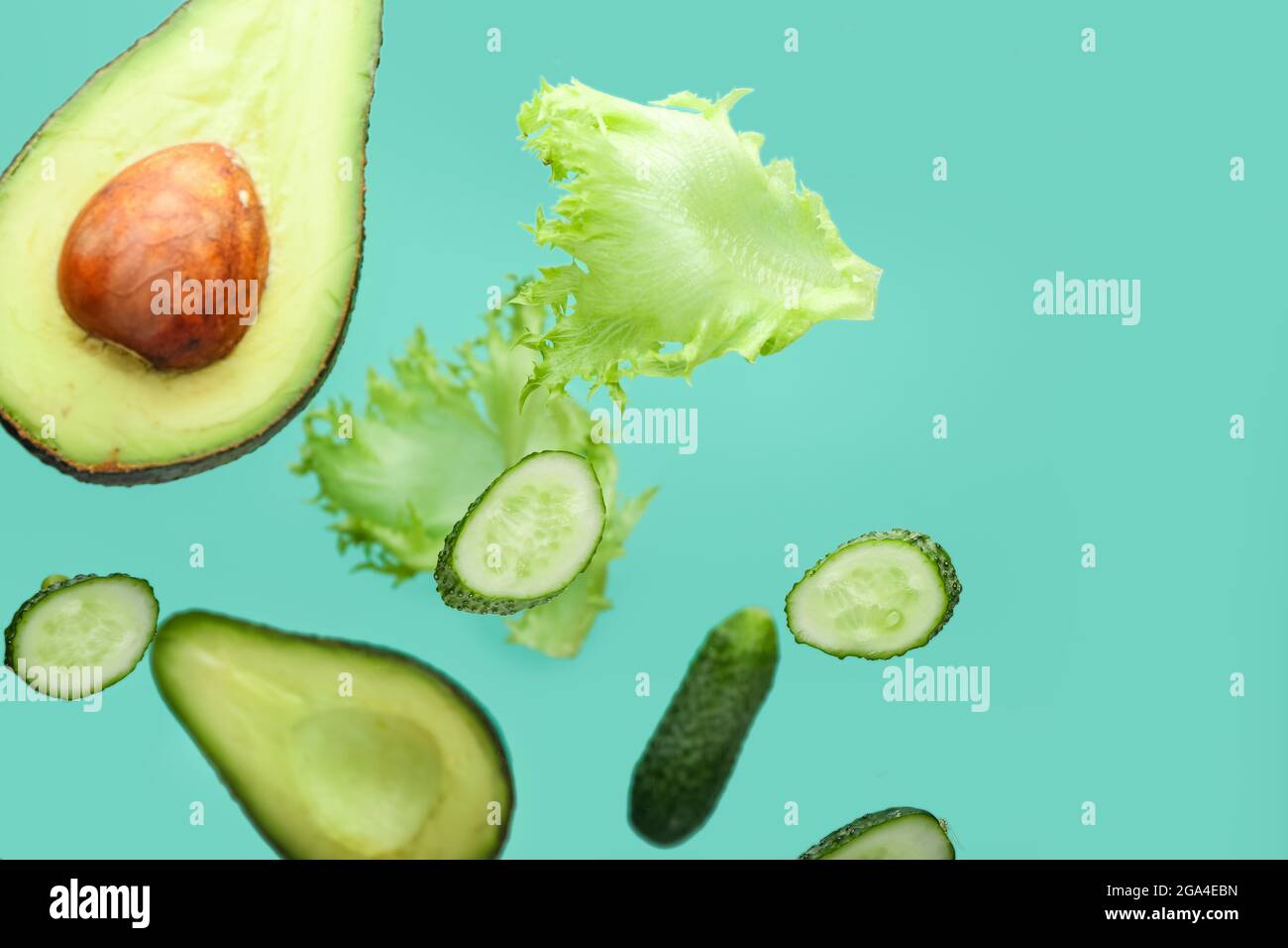 Flying green vegetables on color background Stock Photo