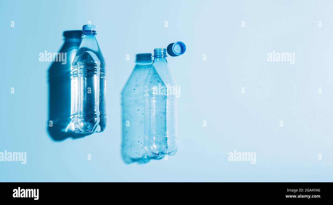 Plastic bottles with water and empty used blue background. Recycling