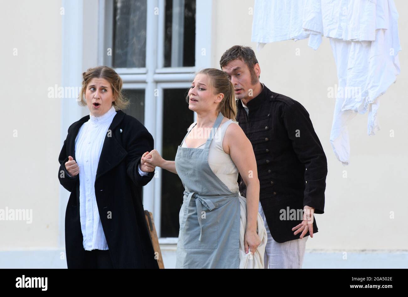 Rheinsberg, Germany. 28th July, 2021. The singers Larissa Angelini (l) as Leonore (Fidelio) and Daniela Ruth Stoll (M) as Marzelline and singer Bartosz Szulc (r) as Rocco sing during the media rehearsal 'Fidelio oder die eheliche Liebe' (Ludwig van Beethoven) in a production by Georg Quander at the Kammeroper Schloß Rheinsberg. Premiere of the opera in three acts is on 04.08.2021, 19.30 clock. Credit: Soeren Stache/dpa-Zentralbild/dpa/Alamy Live News Stock Photo