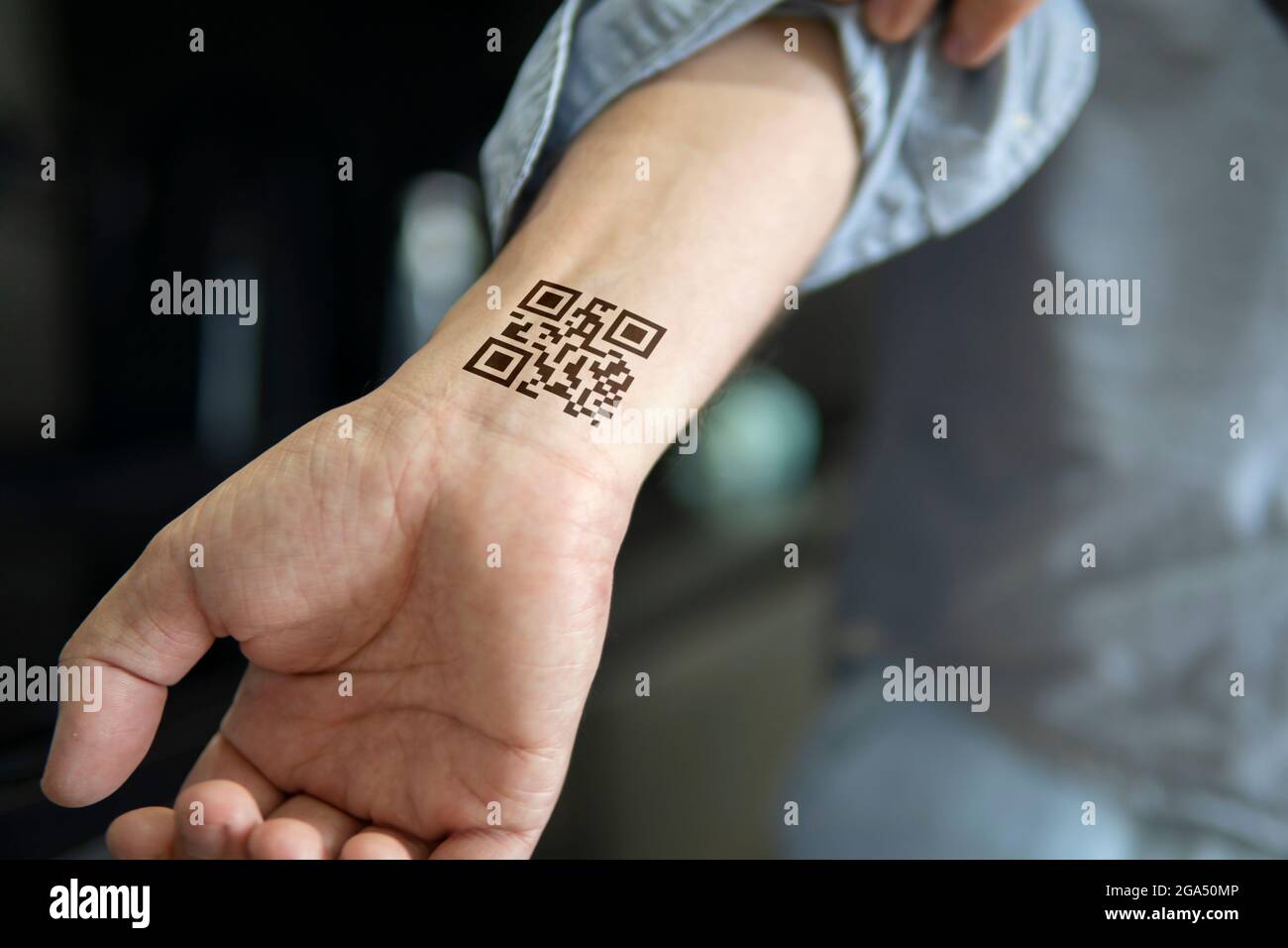 the man shows his hand with a qr code a confirmation of the vaccination against the covid 19 coronavirus temporary tattoo on wrist carpus 2GA50MP