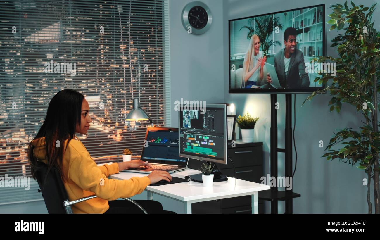African american female video editor works on the computer and mounts