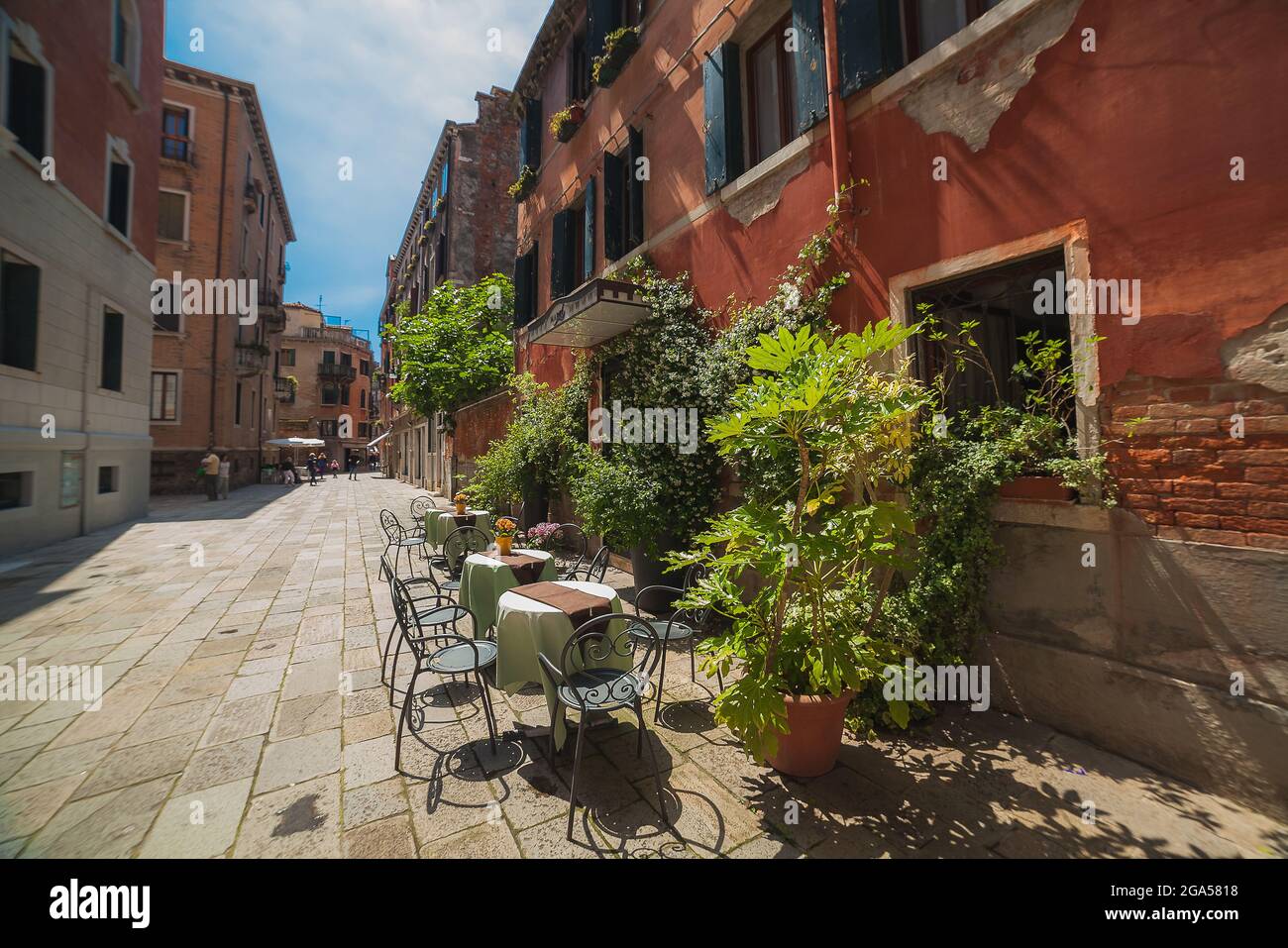 Nice view of sunny morning with some tables of street cafe in Venice Stock Photo