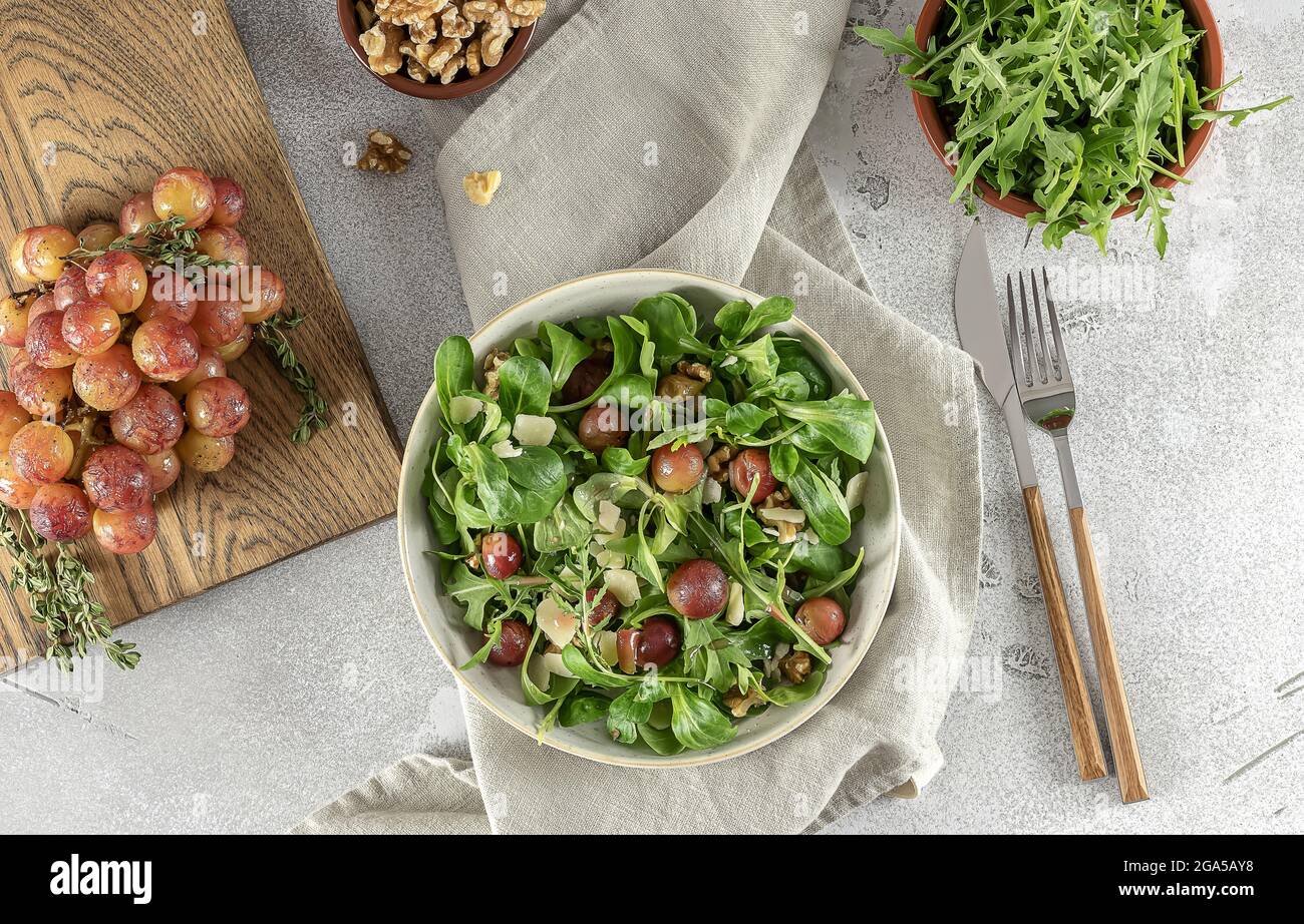 Delicious salad made from caramelized roasted grapes, peppery arugula, toasted walnuts, and pecorino cheese. Stock Photo