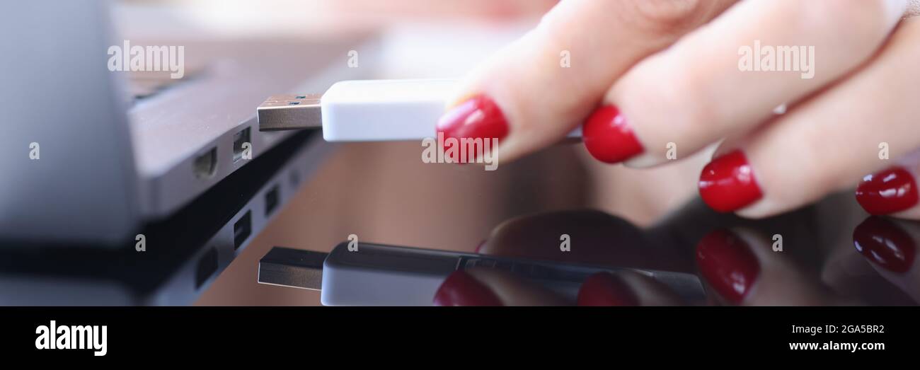 Female hand inserting usb flash into laptop closeup Stock Photo