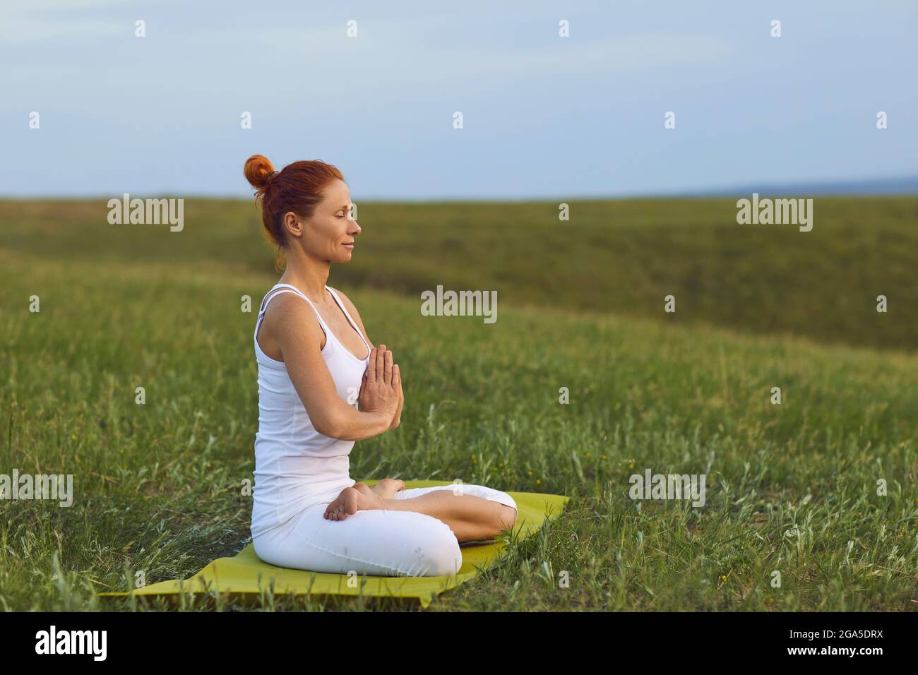 Young woman practices yoga and meditation sitting in lotus position ...