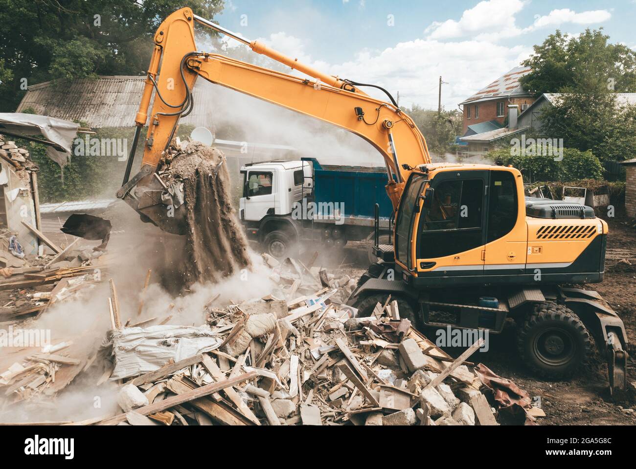 Excavator loads construction waste into truck for removal. Demolition of house. Building
