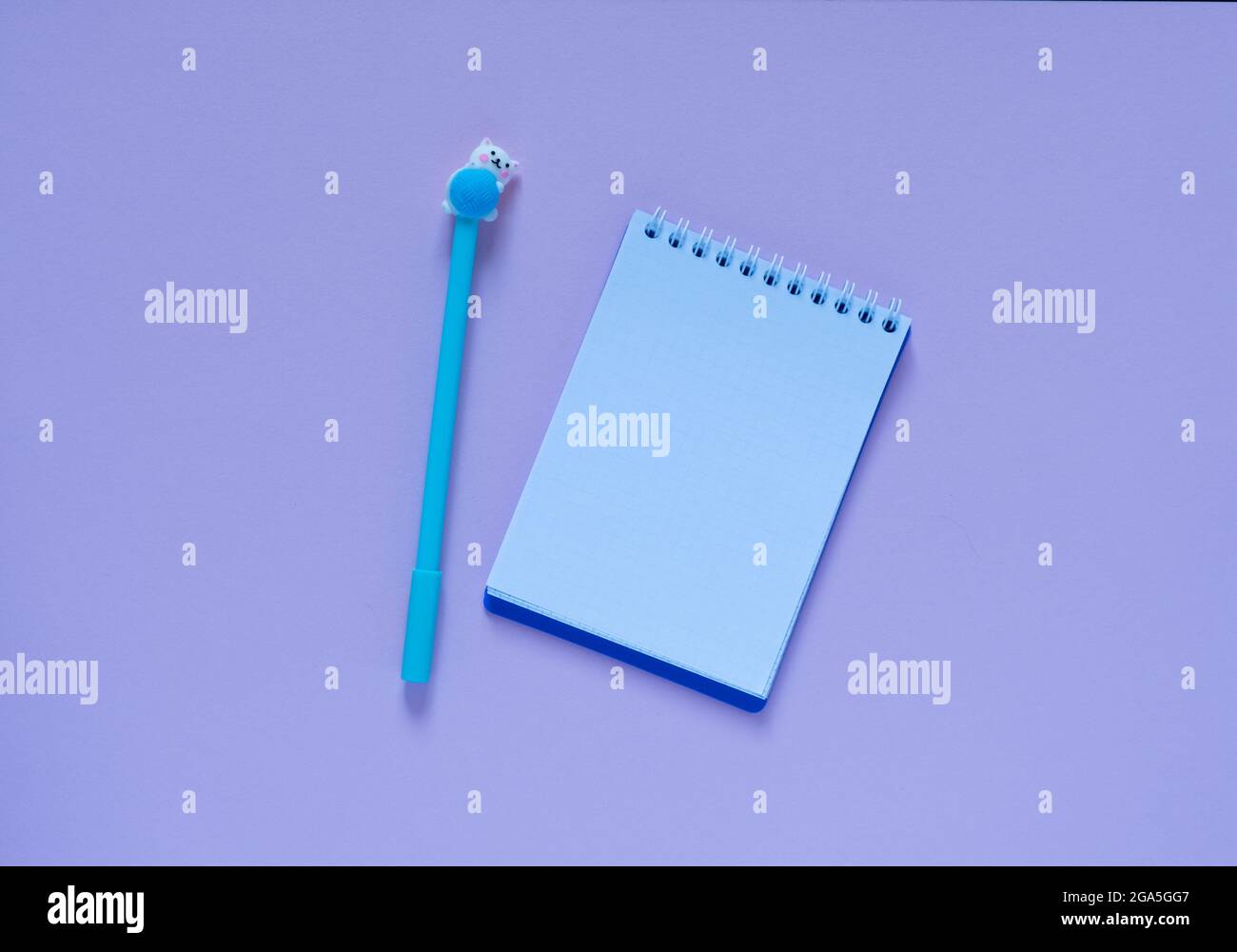 Back to school concept.Notepad and blue pen on a pink background. View ...
