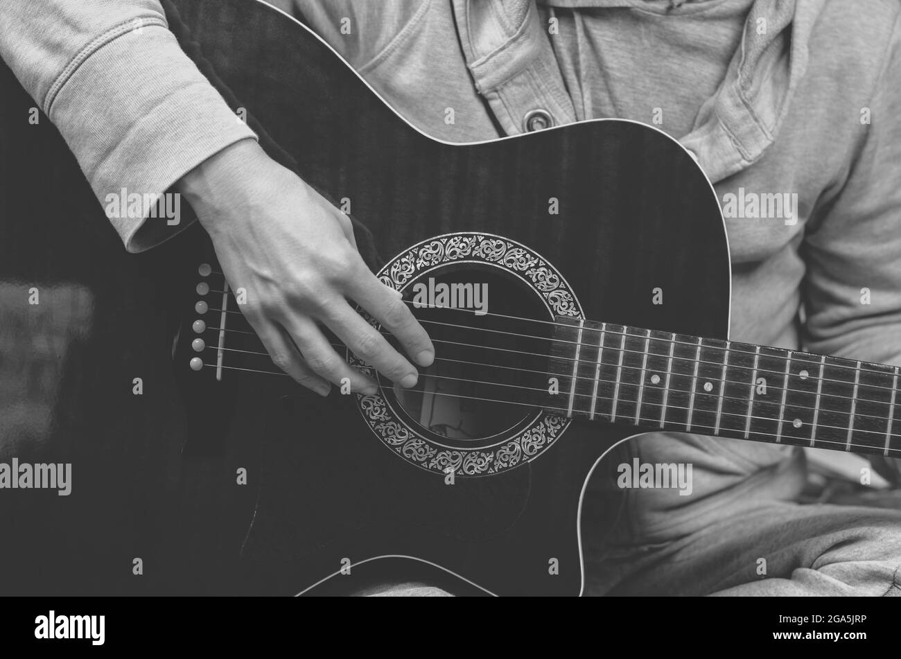 Black and white photo of a musician playing the guitar. Fingers touch ...