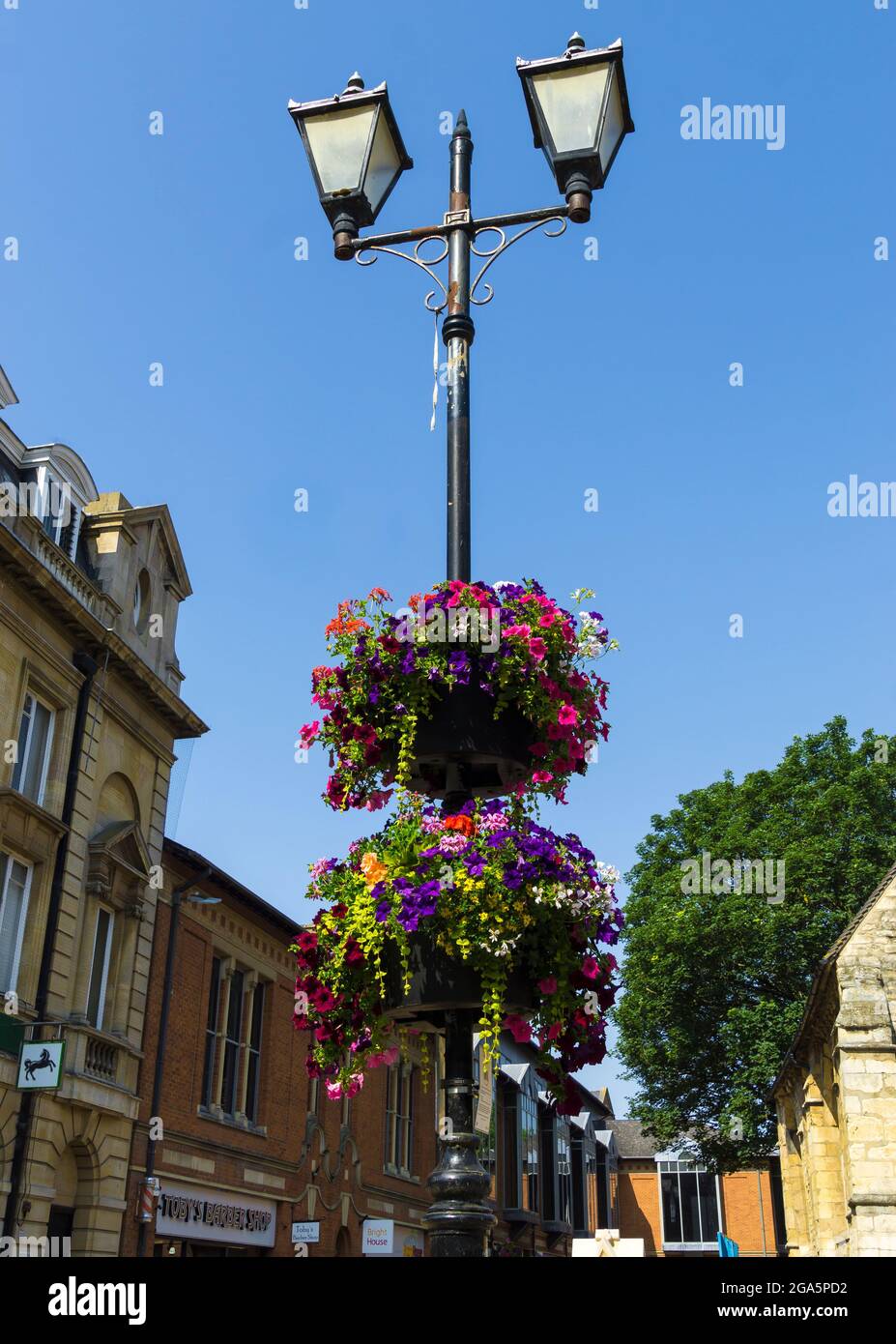 Colourful flower baskets on city twin light lamp post High Street