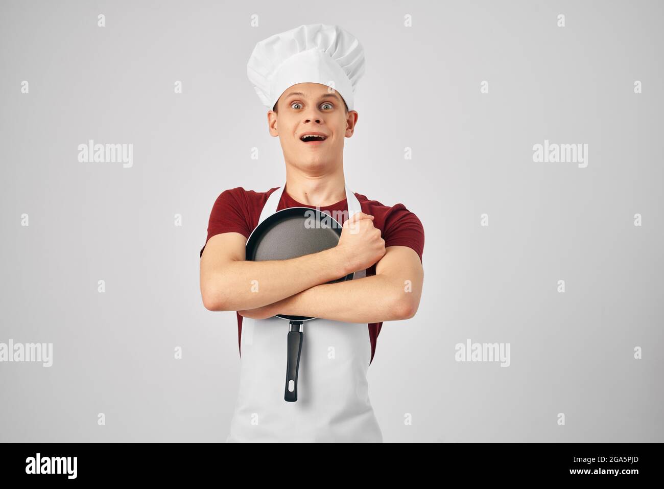 man chef hugging frying pan cooking light background Stock Photo - Alamy