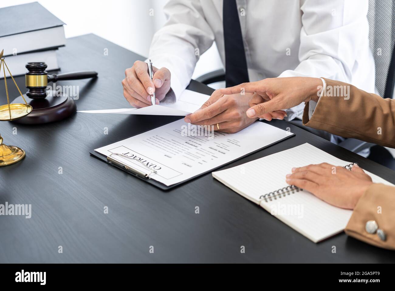 lawyer or judge meeting with client consulting help discussing contract paper agreement Stock Photo