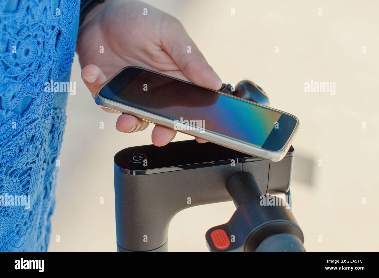 Young man using smartphone to unlock a shared electric scooter. Close up  Stock Photo - Alamy
