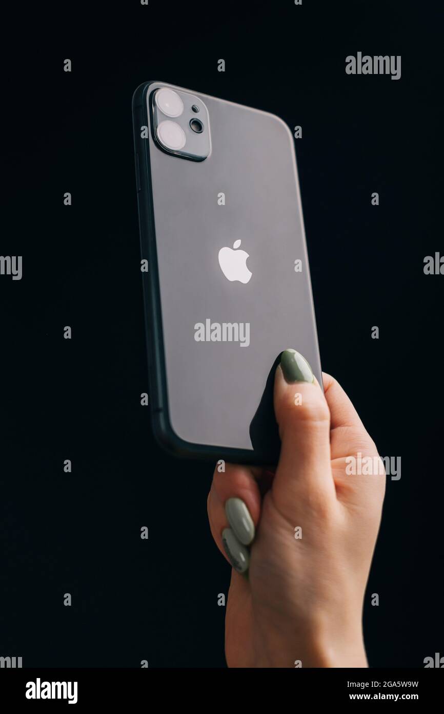 The female hand holds an iPhone 11 on a black background, the apple logo is  deployed to the camera Stock Photo - Alamy