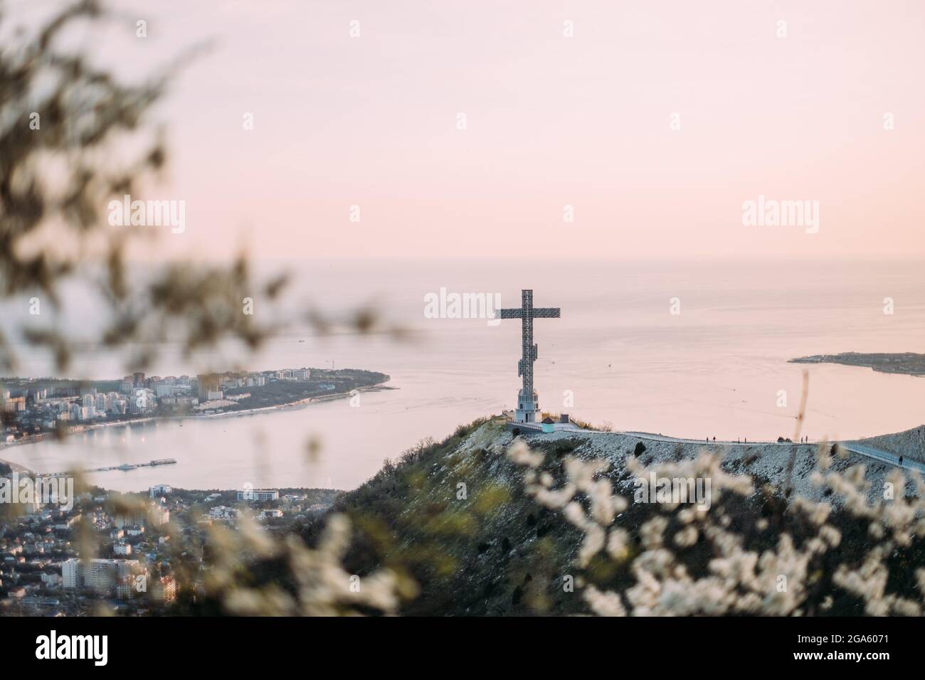 Orthodox cross on Markotkh ridge. A flowering tree in the foreground. Stock Photo