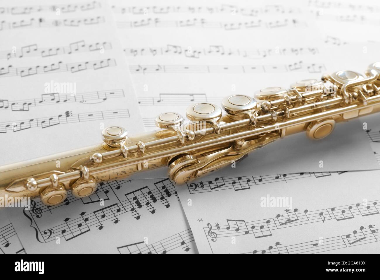 Flute on music notes background Stock Photo - Alamy