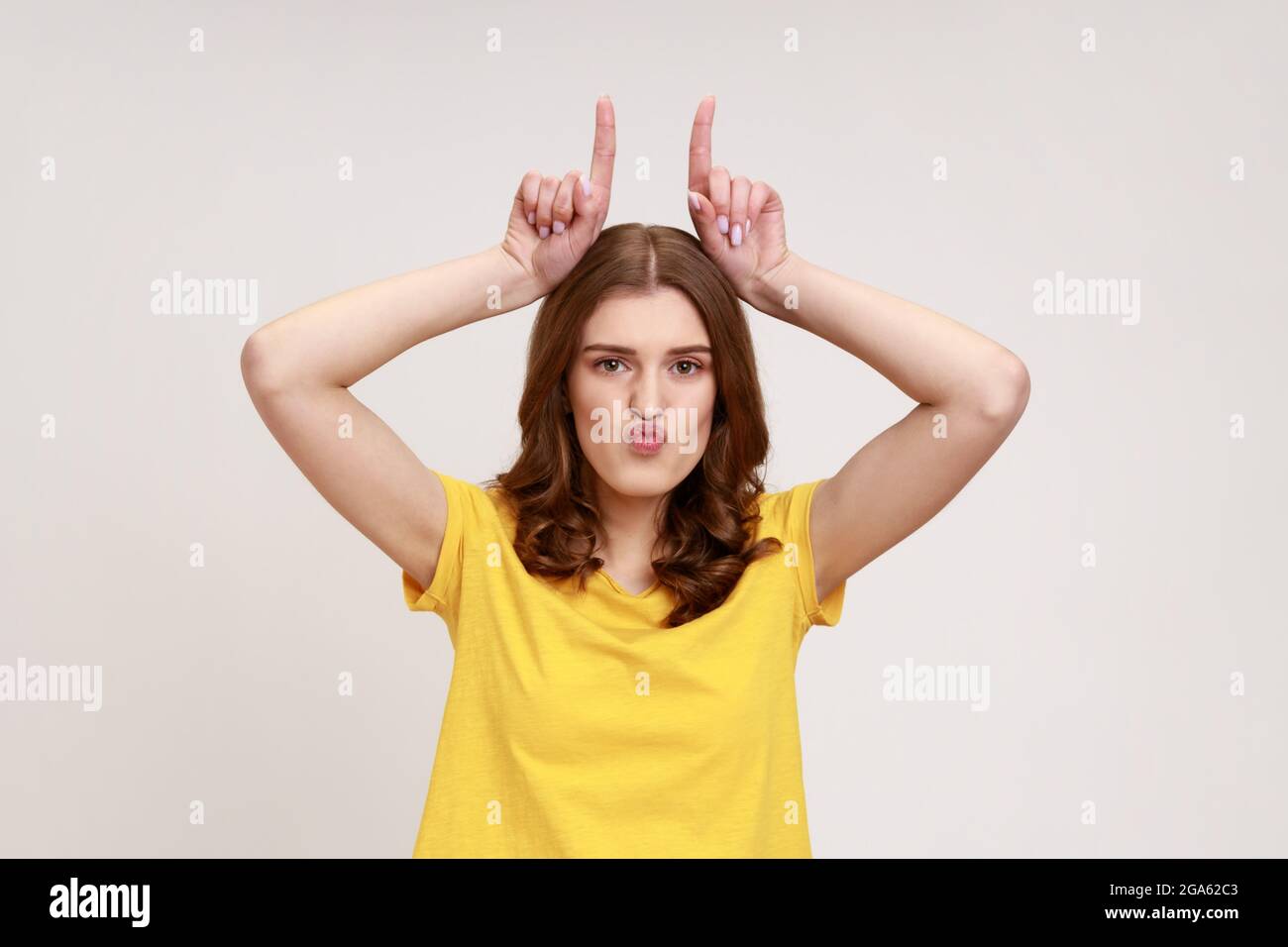 Bully teenager girl in yellow casual Tshirt looking threatening and