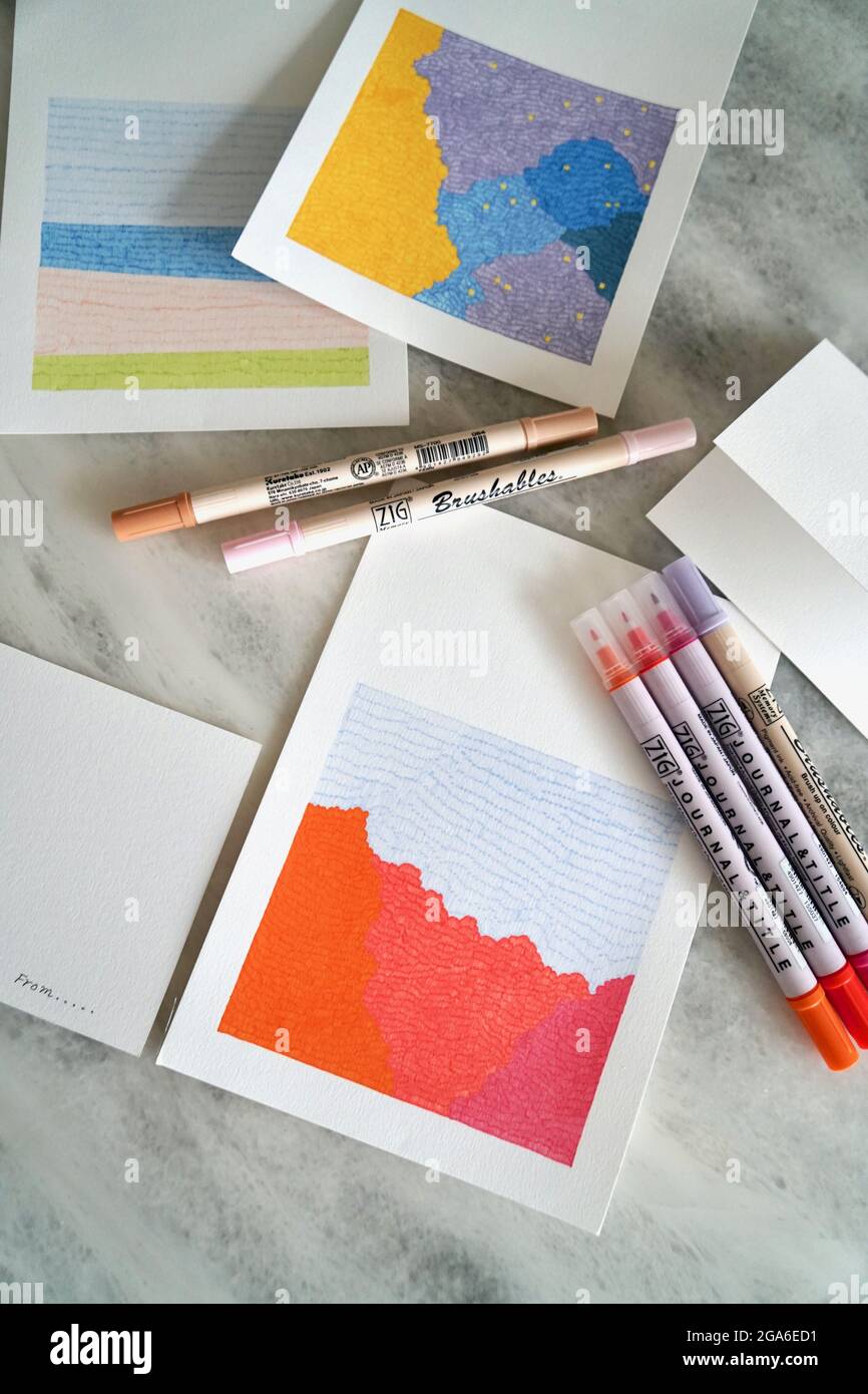 Colored pencils and papers on white background Stock Photo