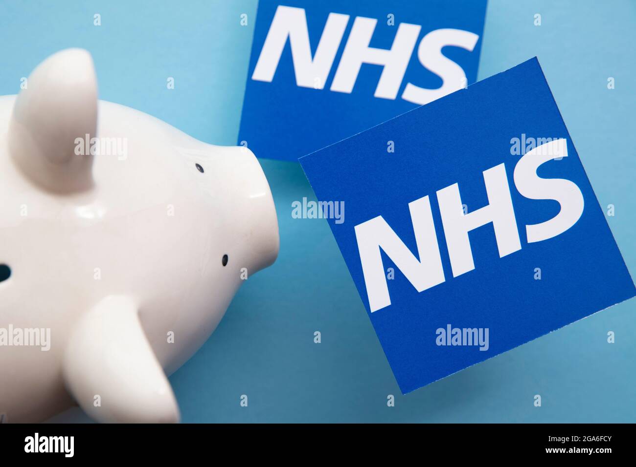 LONDON, UK - July 2021: NHS National health service logo with saving piggy bank Stock Photo